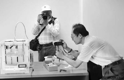 图为网友正在拍摄3D打印机的工作过程。